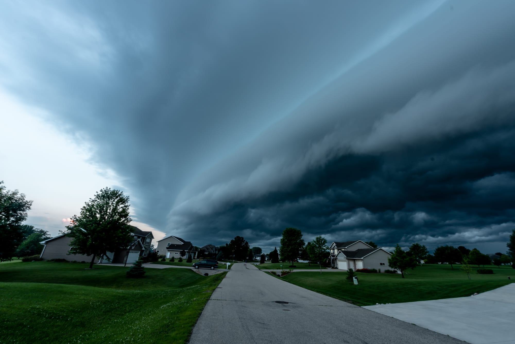 A storm with dark clouds approaching a neighborhood.